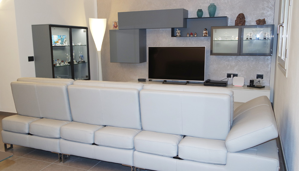 Mid-sized modern open concept family room in Milan with multi-coloured walls, ceramic floors, a built-in media wall and grey floor.