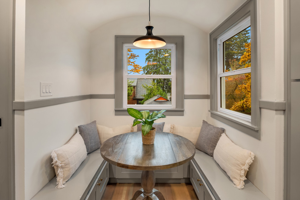 Imagen de comedor de estilo americano con con oficina, paredes blancas, suelo de madera clara y suelo beige