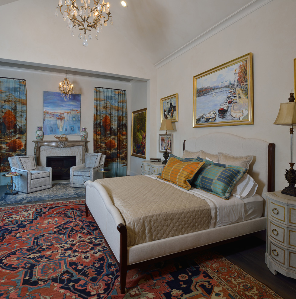This is an example of a large eclectic master bedroom in Houston with white walls, dark hardwood floors, a standard fireplace, a stone fireplace surround and grey floor.