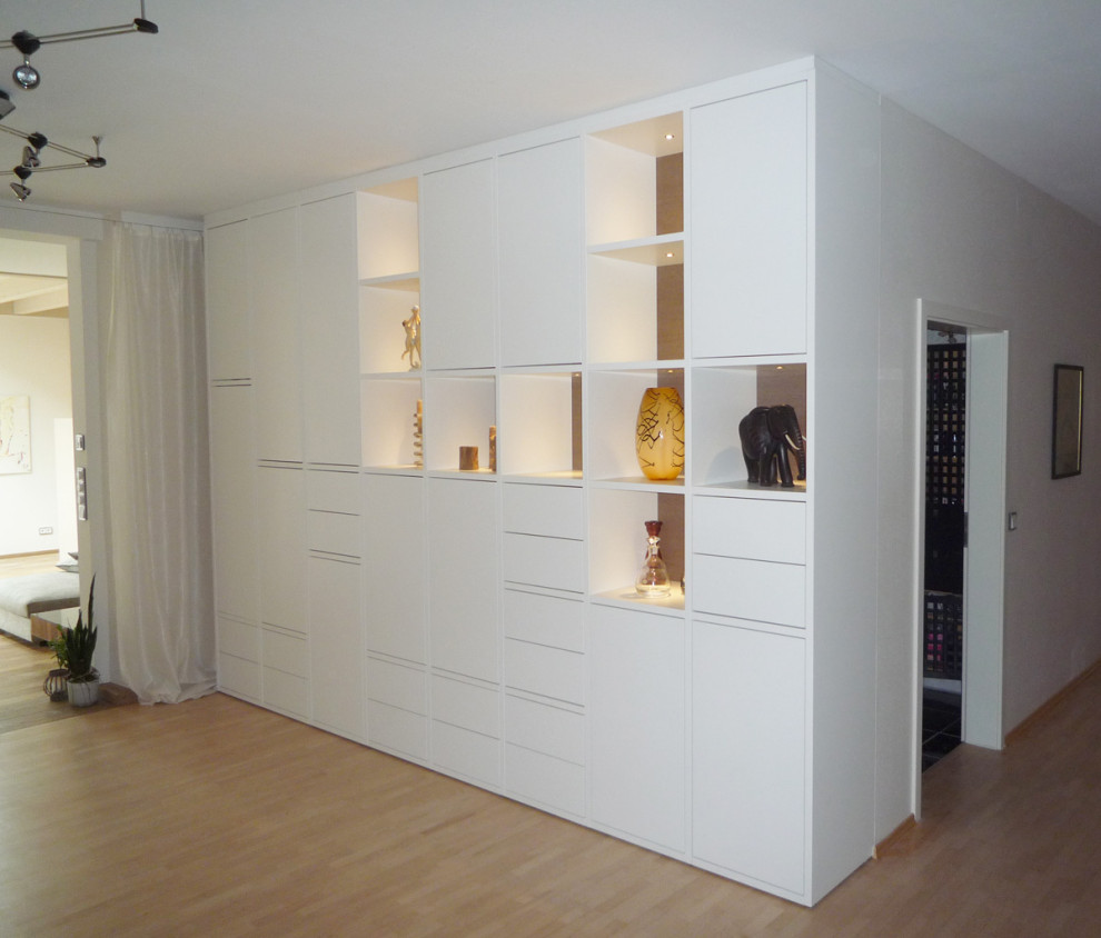 На фото: открытая гостиная комната среднего размера в стиле модернизм с белыми стенами, деревянным полом и коричневым полом