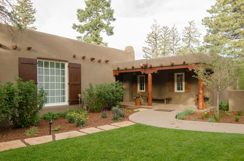 Design ideas for a large one-storey adobe beige exterior in Albuquerque with a flat roof.