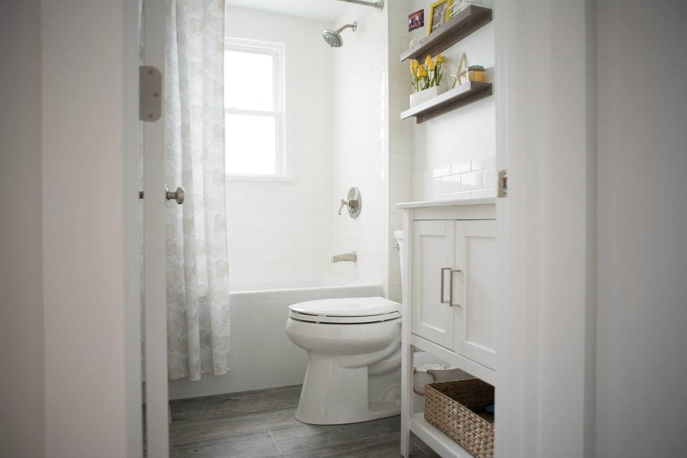 Inspiration for a mid-sized beach style 3/4 bathroom in Providence with shaker cabinets, white cabinets, a corner tub, a shower/bathtub combo, white tile, subway tile, white walls, porcelain floors and an integrated sink.