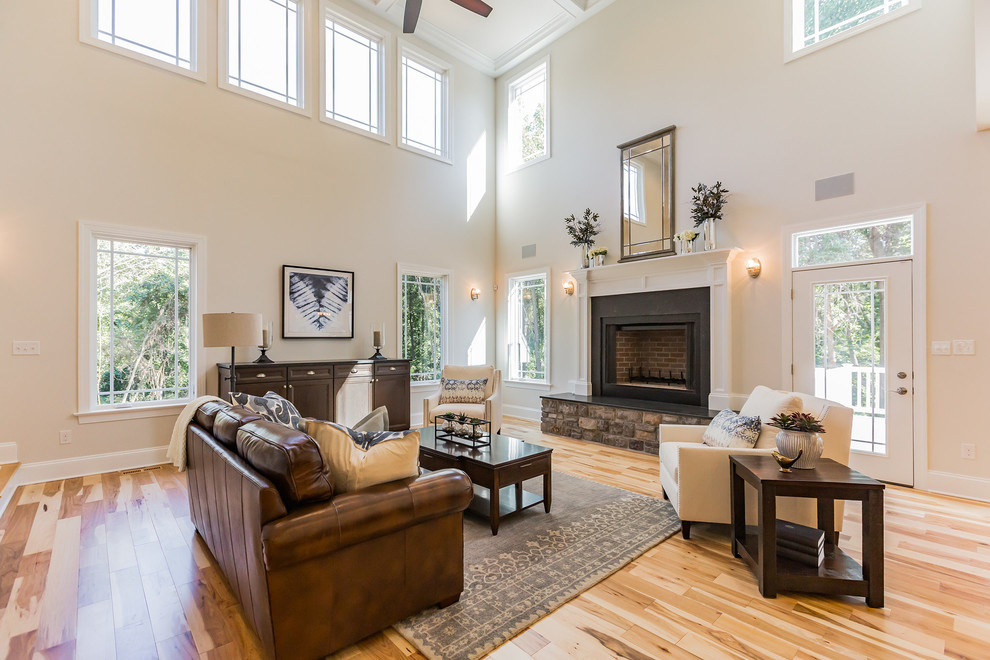 Inspiration for a large traditional open concept family room in Philadelphia with beige walls, light hardwood floors, a standard fireplace, a stone fireplace surround and a built-in media wall.