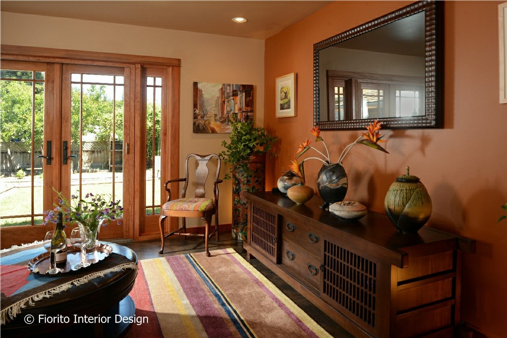 This is an example of a mid-sized eclectic formal enclosed living room in San Francisco with orange walls, concrete floors and brown floor.