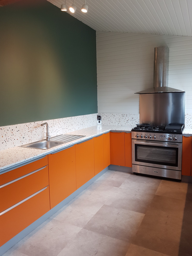 Design ideas for a mid-sized tropical u-shaped separate kitchen in Brest with a single-bowl sink, flat-panel cabinets, orange cabinets, terrazzo benchtops, multi-coloured splashback, stone slab splashback, stainless steel appliances, laminate floors, no island, grey floor and multi-coloured benchtop.