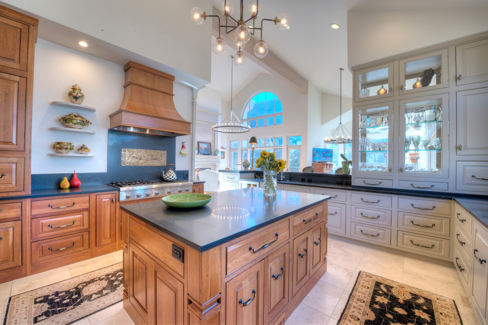 Example of a mid-sized mountain style u-shaped travertine floor enclosed kitchen design in Denver with an undermount sink, beaded inset cabinets, light wood cabinets, quartz countertops, beige backsplash, stone slab backsplash, paneled appliances and an island