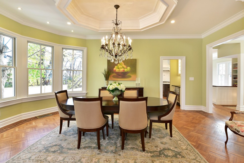 Photo of a large traditional separate dining room in New York with green walls and medium hardwood floors.