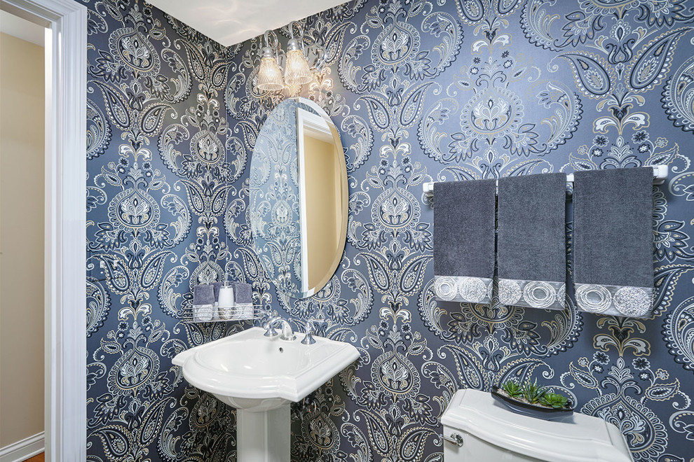 Mid-sized traditional powder room in Chicago with blue walls, dark hardwood floors and a pedestal sink.
