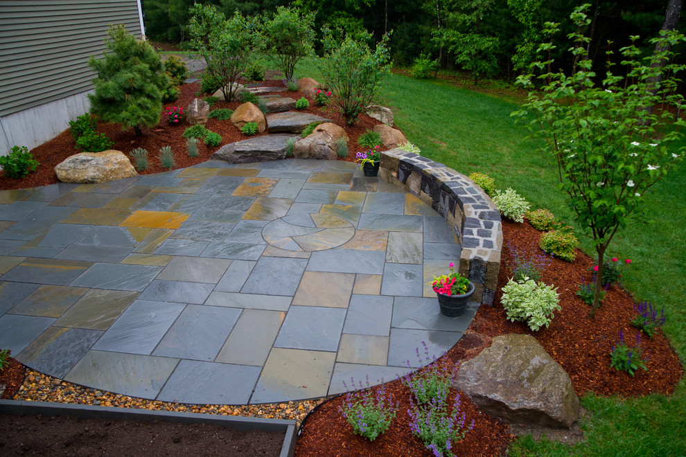 Example of a mid-sized mountain style backyard stone patio design in Boston with no cover