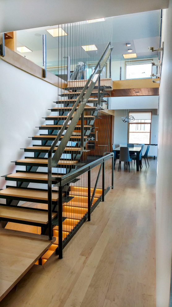 Design ideas for a mid-sized modern wood floating staircase in Denver with open risers and metal railing.