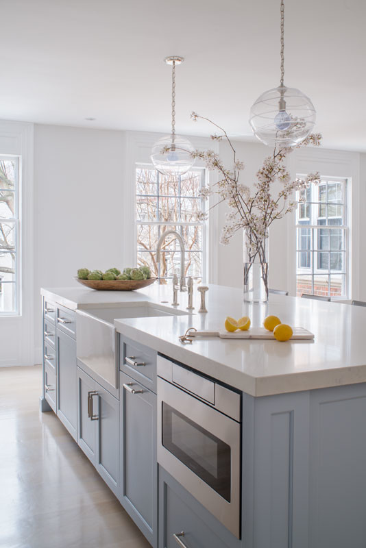 Inspiration for a large transitional single-wall laminate floor and beige floor eat-in kitchen remodel in DC Metro with a farmhouse sink, flat-panel cabinets, blue cabinets, quartz countertops, white backsplash, mosaic tile backsplash, stainless steel appliances, an island and gray countertops