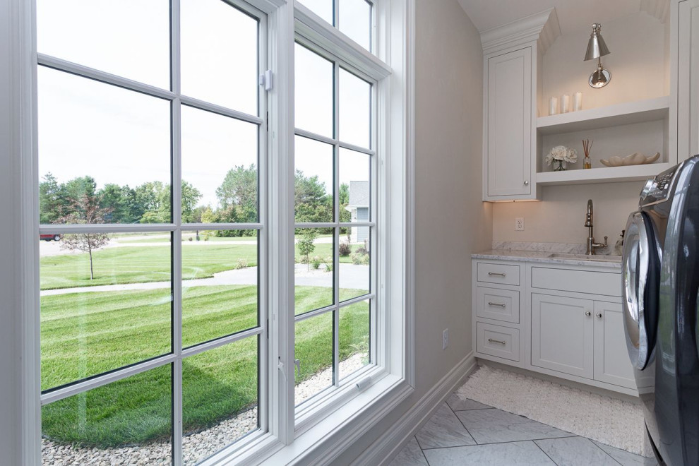 This is an example of a laundry room in Other with white cabinets, marble benchtops, white walls, marble floors, a side-by-side washer and dryer and white floor.