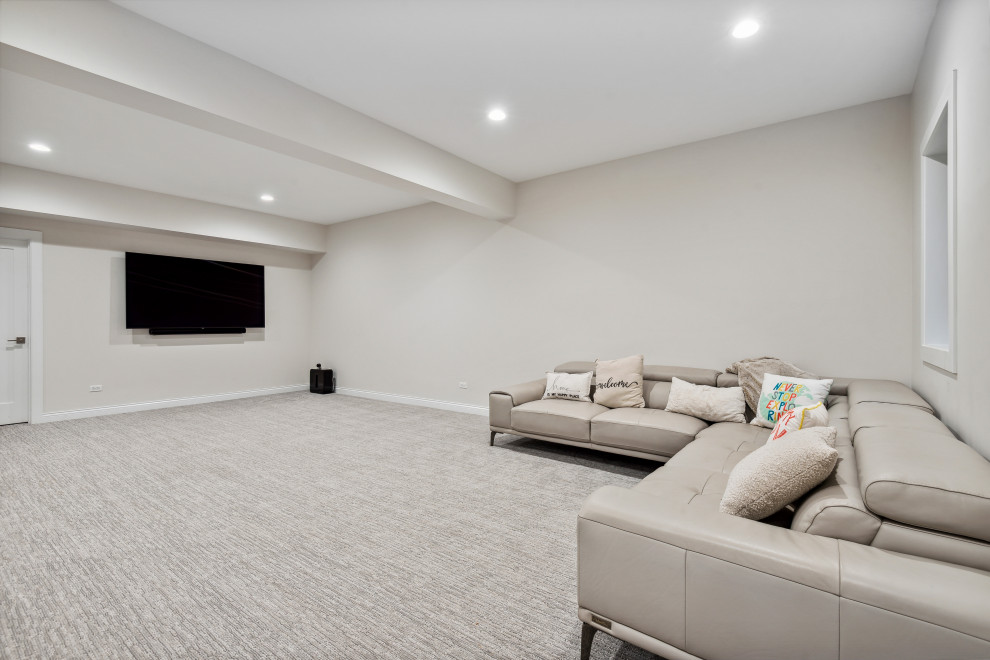 This is an example of a large contemporary fully buried basement in Chicago with a game room, beige walls, carpet and beige floors.