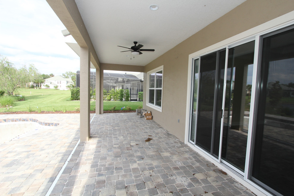Photo of a large transitional backyard verandah in Orlando with brick pavers and a roof extension.