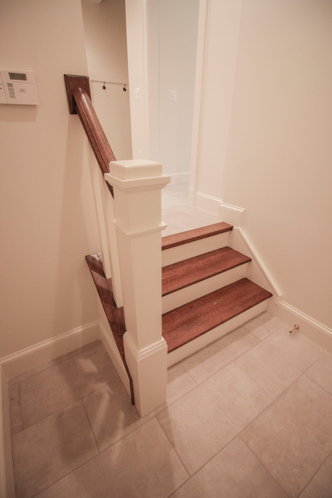 Large transitional wood u-shaped staircase in DC Metro with wood risers, wood railing and decorative wall panelling.