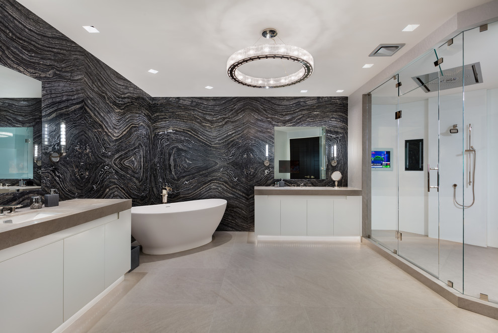 Inspiration for an expansive contemporary bathroom in Miami with flat-panel cabinets, white cabinets, a freestanding tub, a corner shower, black and white tile, black walls, a wall-mount sink, a hinged shower door and grey benchtops.