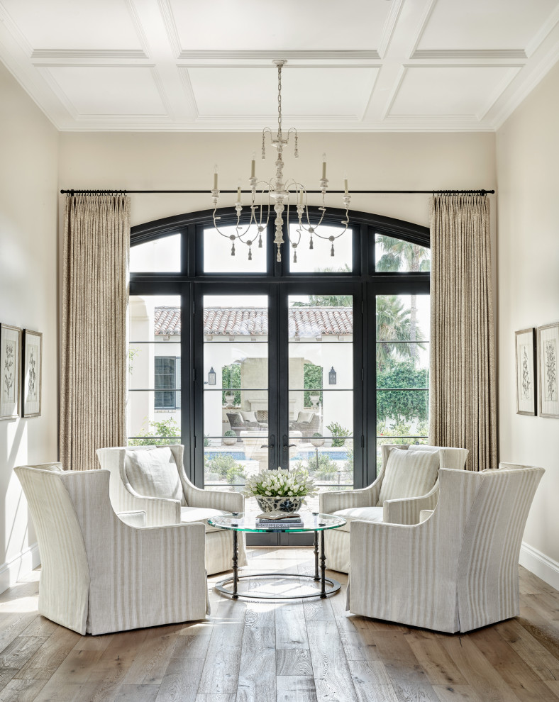 This is an example of a mid-sized mediterranean open concept family room in Phoenix with beige walls, medium hardwood floors, no tv, beige floor and coffered.