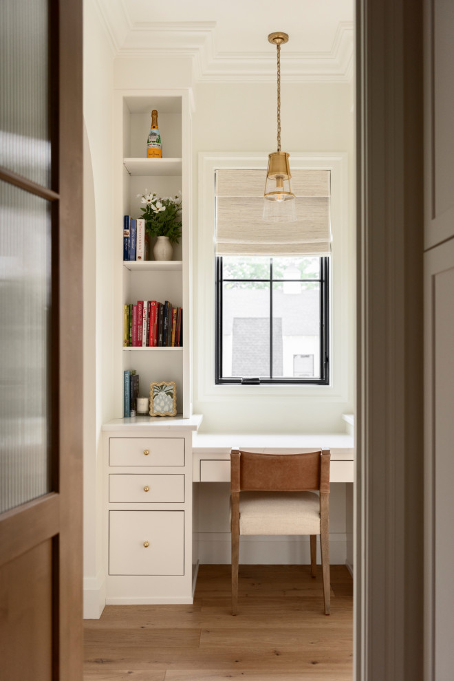 Example of a small transitional built-in desk light wood floor and brown floor home office design in St Louis with white walls