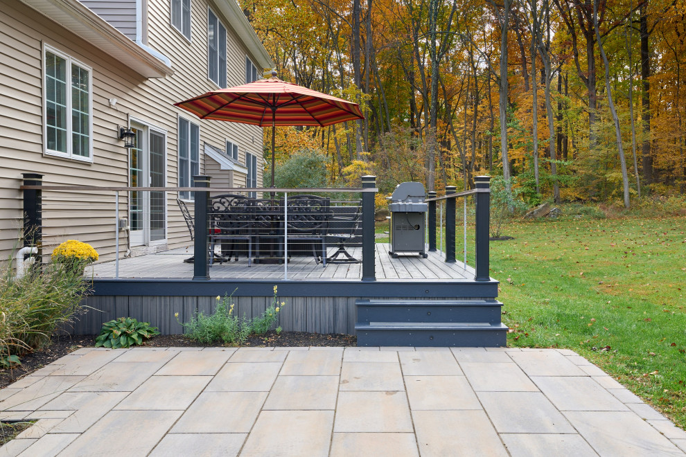 Foto de terraza planta baja contemporánea de tamaño medio en patio trasero con privacidad y barandilla de cable