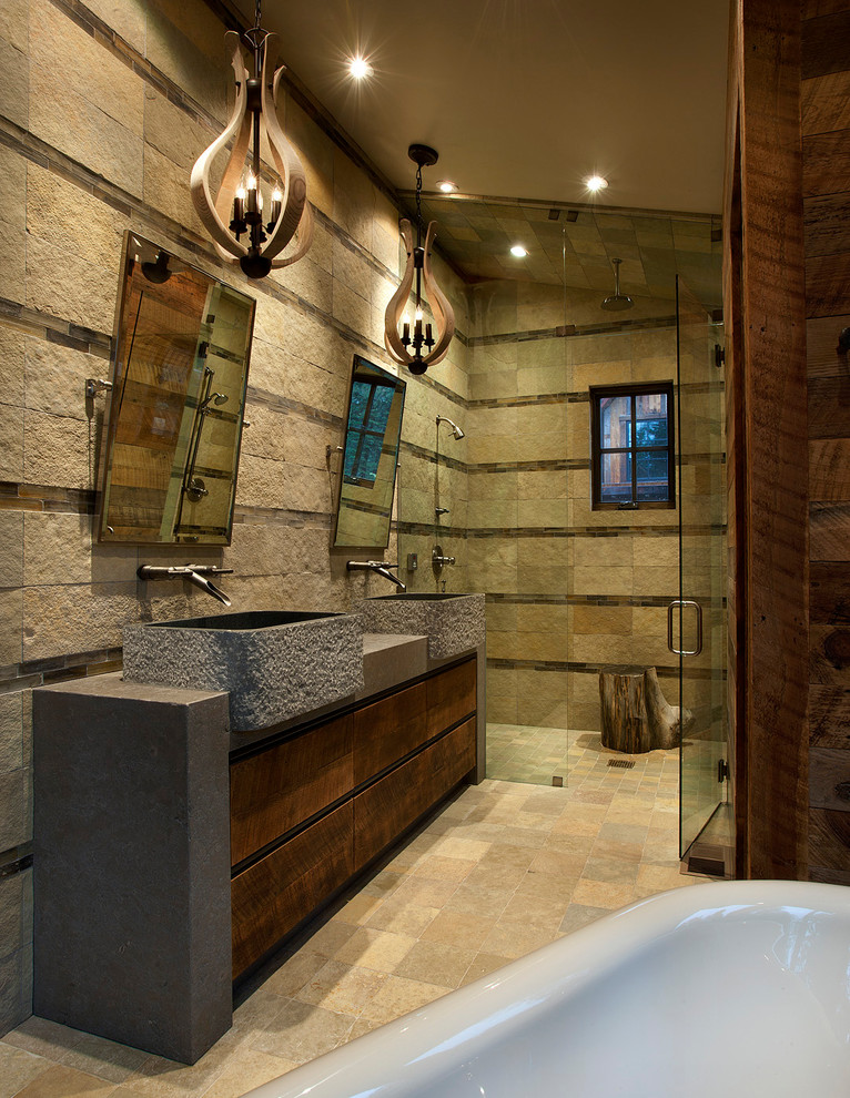 Photo of a large country master wet room bathroom in Sacramento with stone tile, limestone floors, beige floor, flat-panel cabinets, dark wood cabinets, beige tile, brown tile, brown walls, a vessel sink, concrete benchtops and a hinged shower door.