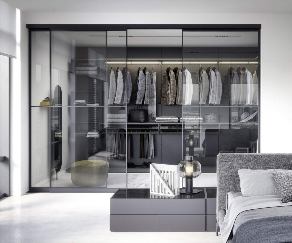 Large modern gender-neutral dressing room in Stuttgart with glass-front cabinets.