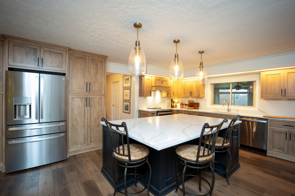 Eat-in kitchen - large transitional l-shaped medium tone wood floor and brown floor eat-in kitchen idea with a single-bowl sink, shaker cabinets, medium tone wood cabinets, quartz countertops, white backsplash, quartz backsplash, stainless steel appliances, an island and white countertops
