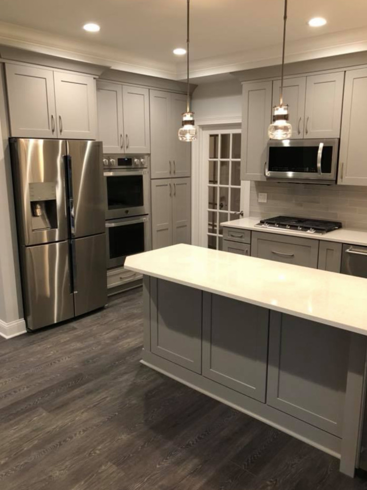 Kitchen - transitional u-shaped gray floor kitchen idea with an undermount sink, recessed-panel cabinets, gray cabinets, gray backsplash, stainless steel appliances and white countertops
