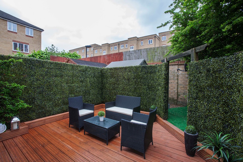 Design ideas for a transitional backyard patio in London with decking and no cover.