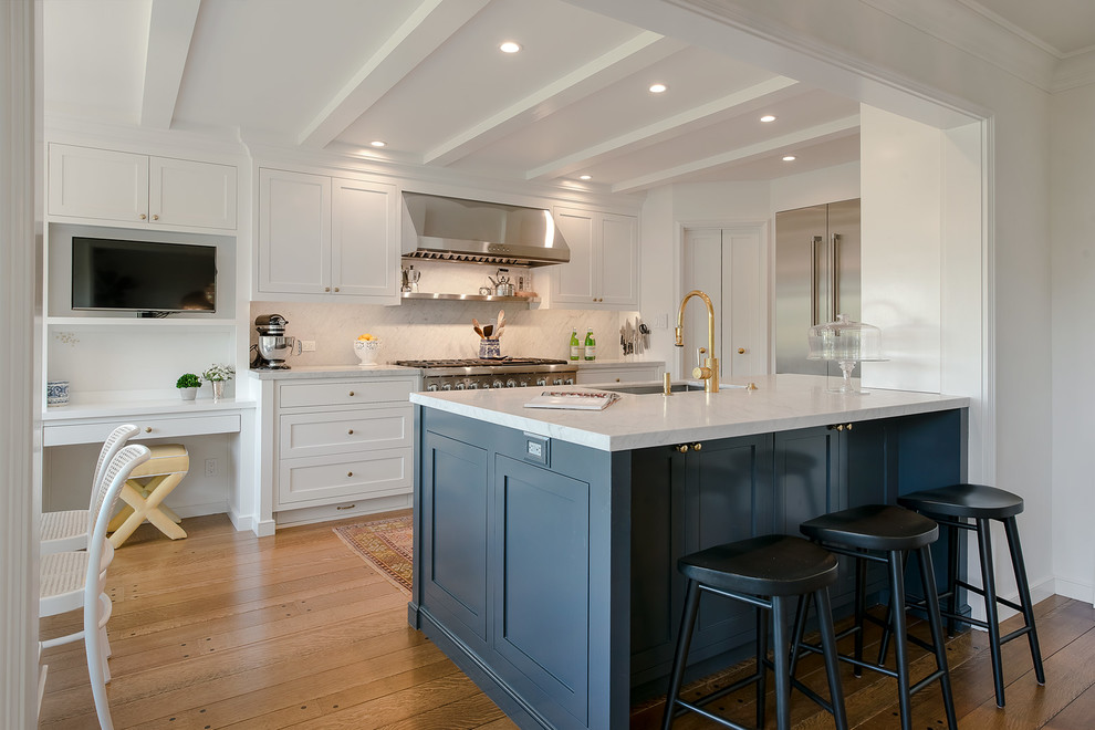 Transitional eat-in kitchen in San Francisco with shaker cabinets, an undermount sink, white cabinets, white splashback, stainless steel appliances, medium hardwood floors and a peninsula.