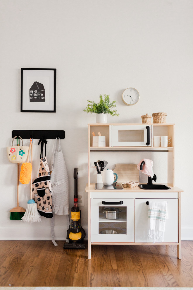 Contemporary Kids - Example of a trendy girl medium tone wood floor and brown floor playroom design in Portland with white walls