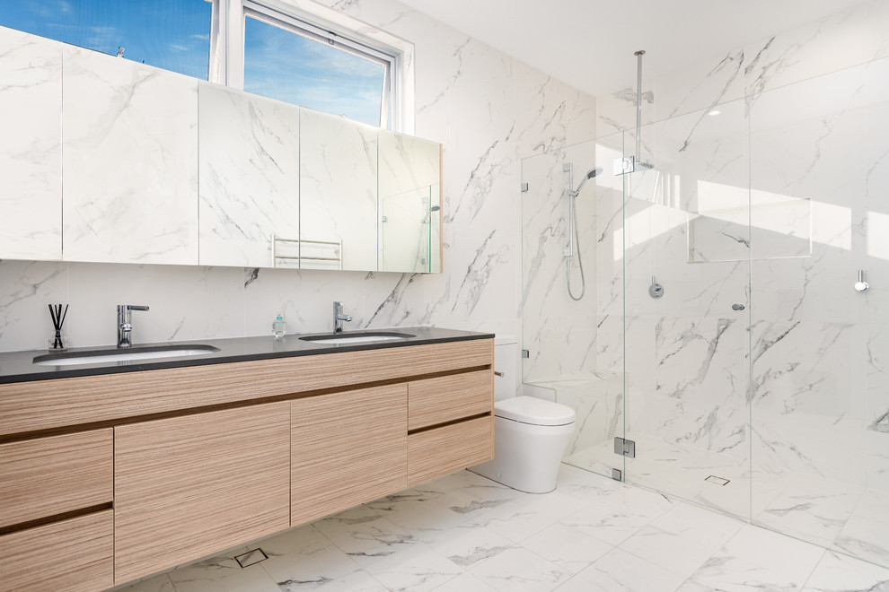 This is an example of a contemporary master bathroom in Sydney with flat-panel cabinets, beige cabinets, an alcove shower, a one-piece toilet, gray tile, an undermount sink, grey floor, a hinged shower door, engineered quartz benchtops and grey benchtops.