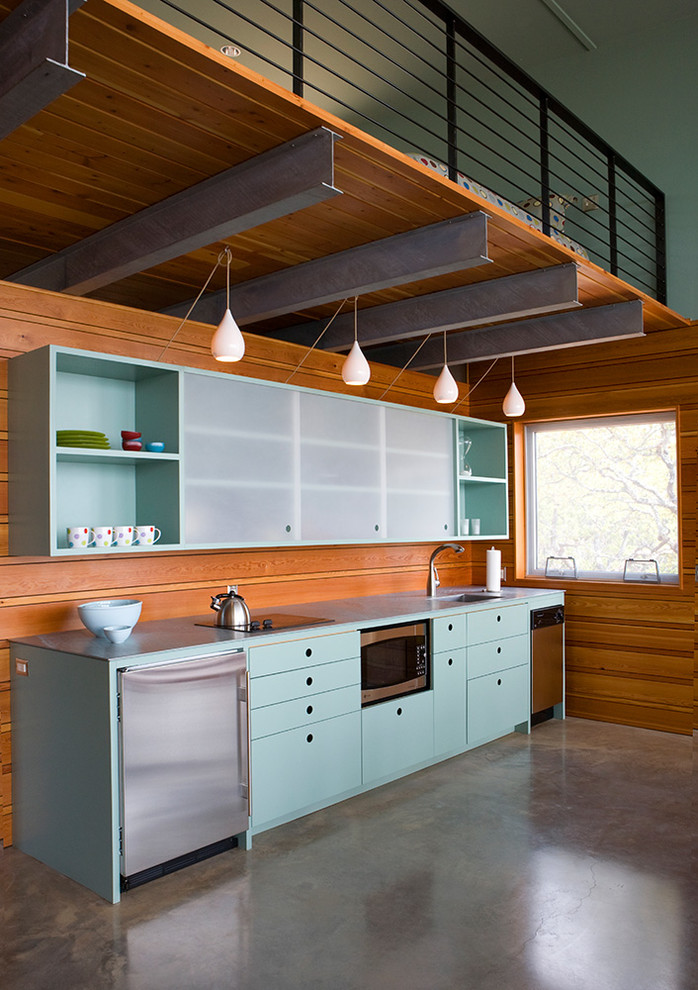 Inspiration for a mid-sized contemporary l-shaped eat-in kitchen in Austin with a drop-in sink, flat-panel cabinets, blue cabinets, stainless steel benchtops, brown splashback, stainless steel appliances, concrete floors and no island.