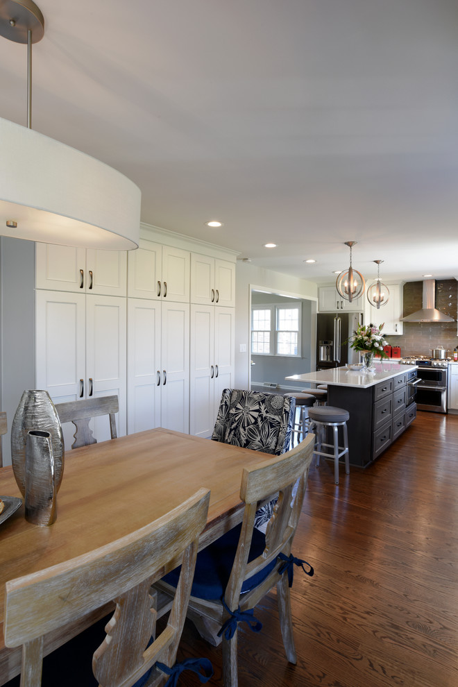 Eat-in kitchen - transitional l-shaped medium tone wood floor eat-in kitchen idea in Orange County with a double-bowl sink, shaker cabinets, white cabinets, marble countertops, gray backsplash, glass tile backsplash, stainless steel appliances and an island
