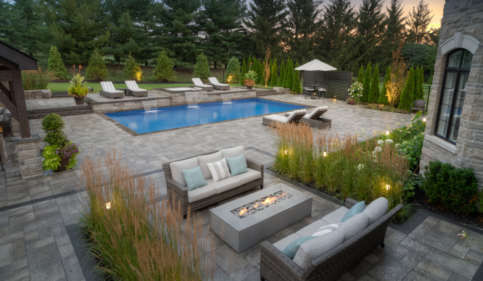 Pool landscaping - large transitional backyard brick and rectangular lap pool landscaping idea in Toronto