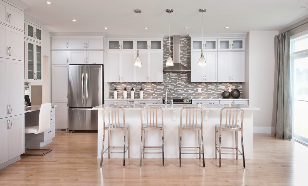Photo of a contemporary l-shaped kitchen in Ottawa with shaker cabinets, white cabinets, grey splashback, matchstick tile splashback and stainless steel appliances.