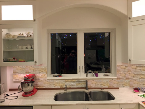 How should stone backsplash flow around the window area?