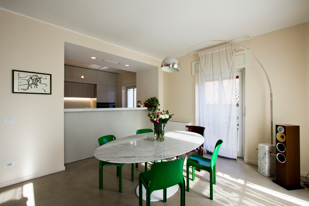 Design ideas for a large contemporary kitchen/dining combo in Milan with pink walls, concrete floors and grey floor.