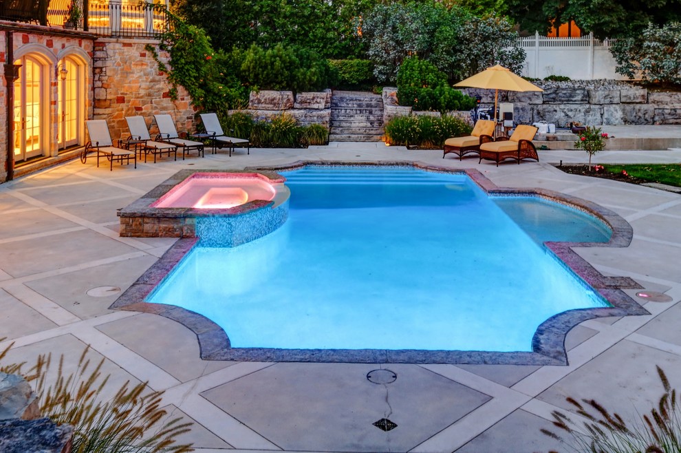 Mid-sized traditional backyard rectangular pool in Toronto with a hot tub and stamped concrete.