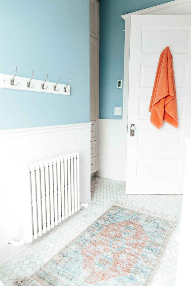 Photo of a mid-sized transitional kids bathroom in Other with shaker cabinets, white cabinets, an alcove tub, a shower/bathtub combo, a one-piece toilet, gray tile, subway tile, blue walls, ceramic floors, a drop-in sink, granite benchtops, multi-coloured floor, a shower curtain, multi-coloured benchtops, a niche, a double vanity and a built-in vanity.