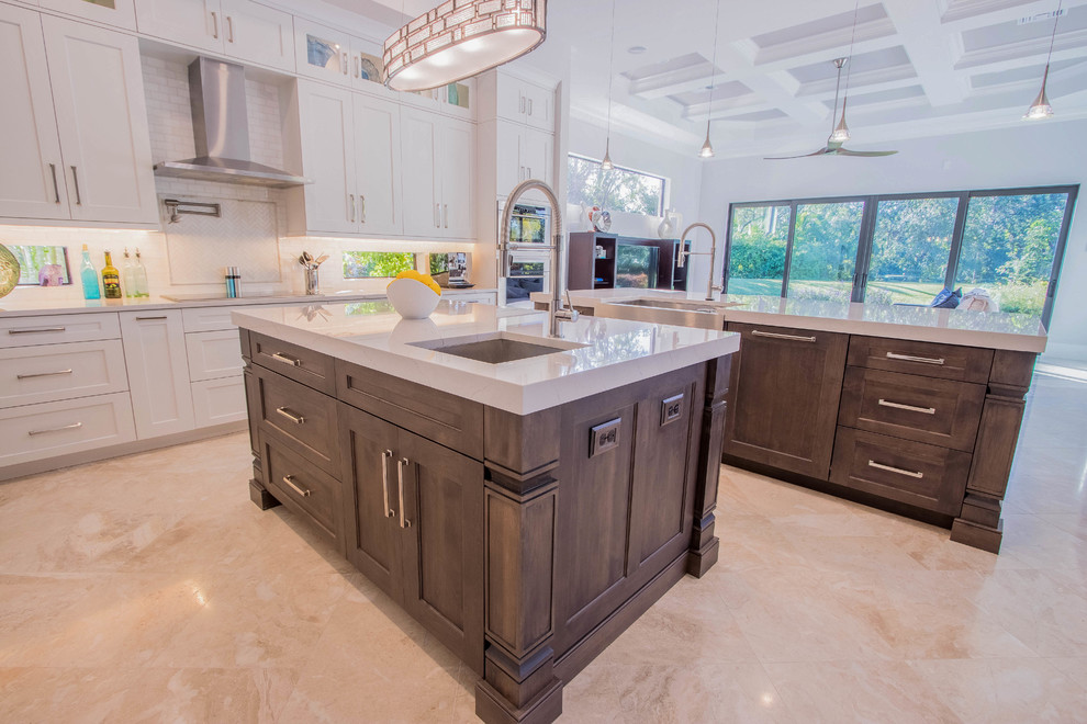 Huge transitional l-shaped porcelain tile and beige floor open concept kitchen photo with a farmhouse sink, shaker cabinets, white cabinets, quartz countertops, white backsplash, porcelain backsplash, stainless steel appliances and two islands