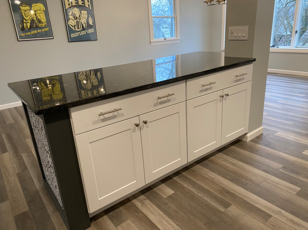 Inspiration for a large transitional l-shaped vinyl floor and gray floor open concept kitchen remodel in Cincinnati with an undermount sink, raised-panel cabinets, white cabinets, granite countertops, multicolored backsplash, ceramic backsplash, stainless steel appliances, an island and black countertops