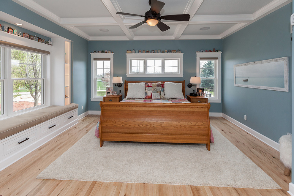 This is an example of a mid-sized contemporary master bedroom in Other with blue walls, light hardwood floors, no fireplace and brown floor.