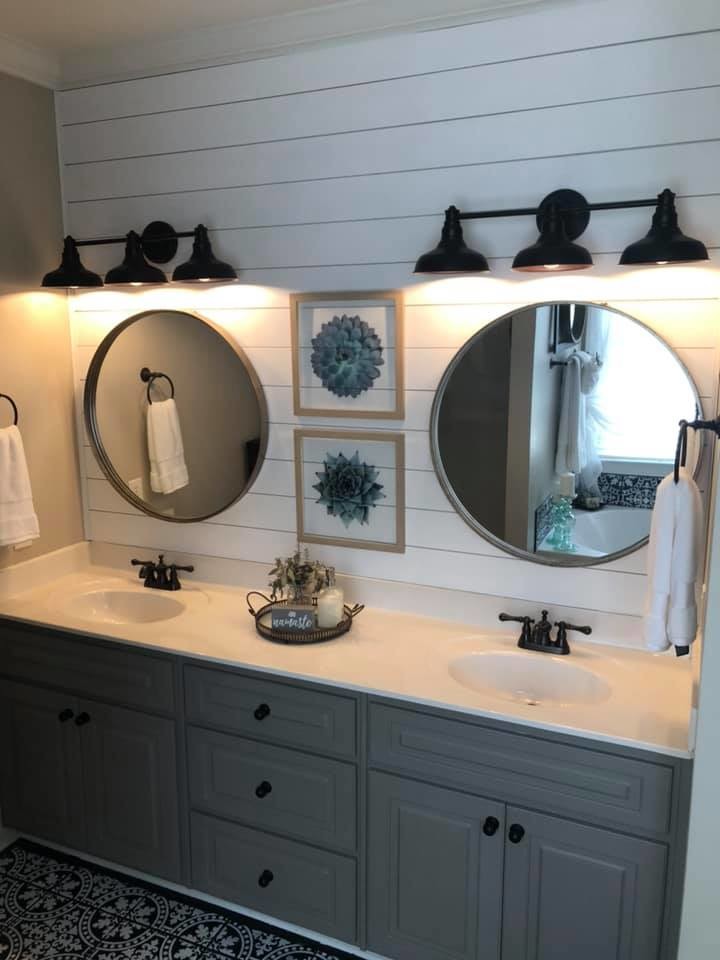 This is an example of a mid-sized country master bathroom in Other with raised-panel cabinets, grey cabinets, white walls, porcelain floors, solid surface benchtops, black floor and white benchtops.
