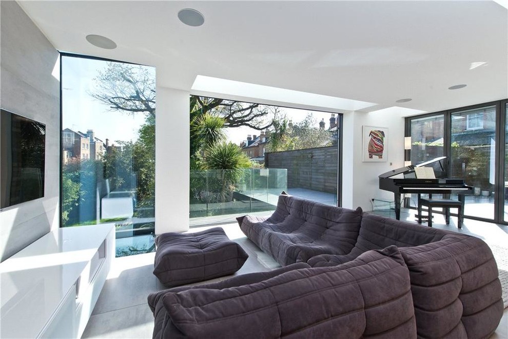 Photo of a large contemporary open concept living room in London with white walls, ceramic floors, grey floor, a music area and a wall-mounted tv.