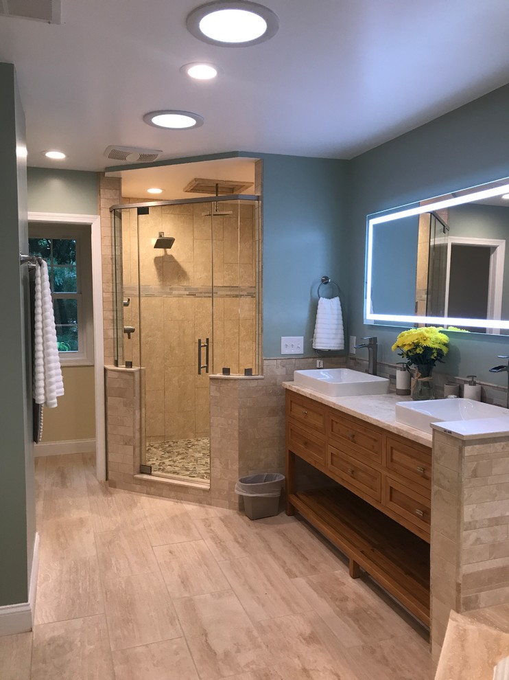 Design ideas for a large transitional master bathroom in DC Metro with open cabinets, medium wood cabinets, a corner tub, a corner shower, a two-piece toilet, green tile, travertine, green walls, marble floors, a vessel sink, marble benchtops and a hinged shower door.