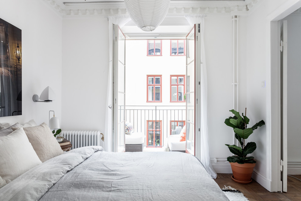 Inspiration for a mid-sized scandinavian master bedroom in Stockholm with white walls, light hardwood floors and no fireplace.