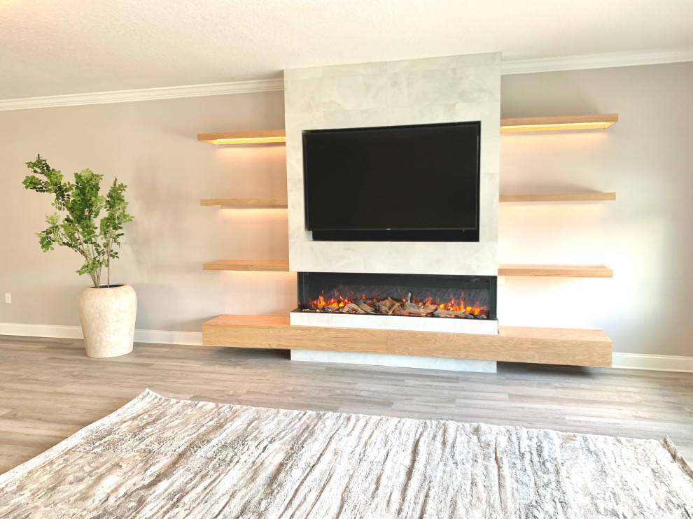 Example of a large transitional loft-style vinyl floor and gray floor family room design in Orlando with gray walls, a standard fireplace, a tile fireplace and a media wall
