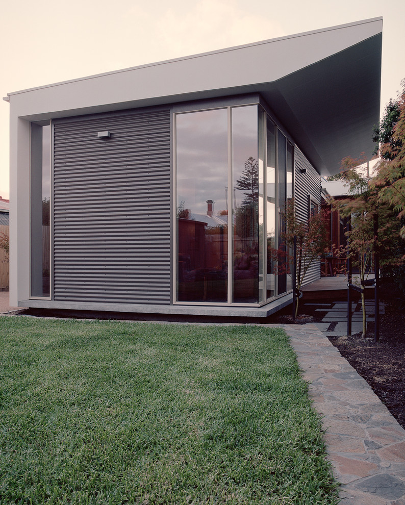 This is an example of a mid-sized contemporary one-storey exterior in Melbourne with wood siding and a flat roof.
