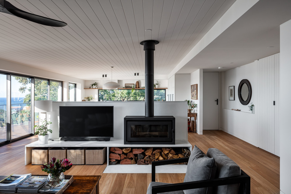 Esempio di un soggiorno stile marinaro di medie dimensioni e aperto con pareti bianche, stufa a legna, TV autoportante e soffitto ribassato
