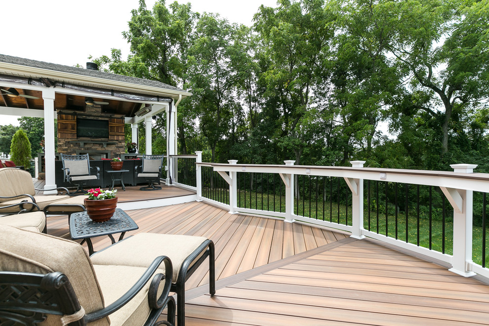 This is an example of a large traditional backyard deck in Baltimore with a roof extension.